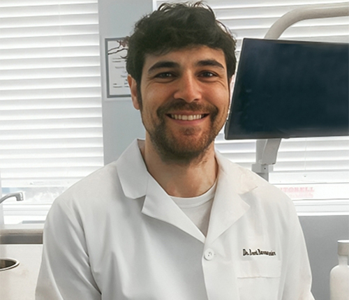 Young male dental professional smiling in white coat at Marion DDS dental office