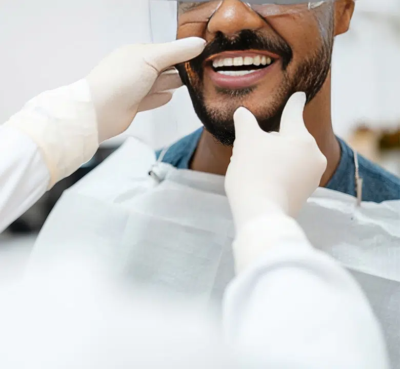 Dentist examining patient's teeth during checkup in clinical setting.