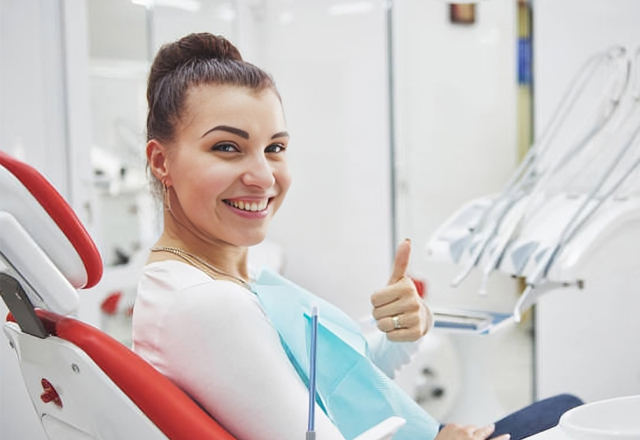 Young patient giving thumbs up in dental chair at Marion DDS office